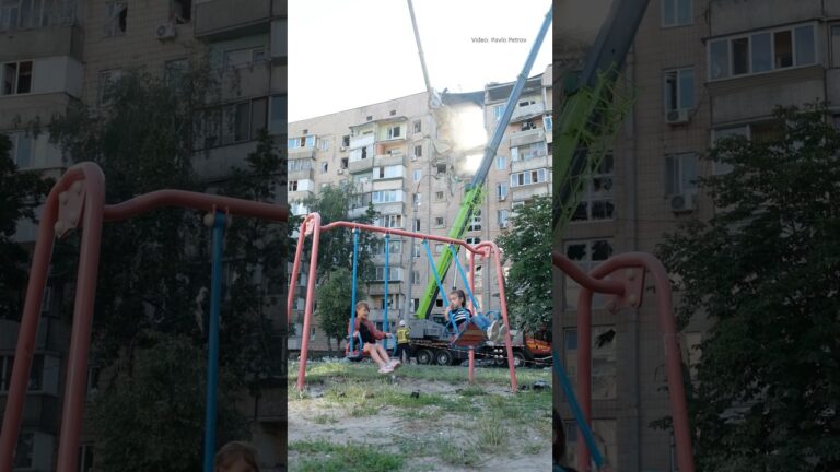 Фото для новини:Children swing on a playground beside a building struck by a Russian attack in Kyiv on July 6